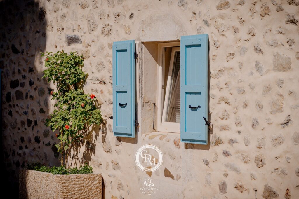 Volets bleus et façade en pierres apparentes